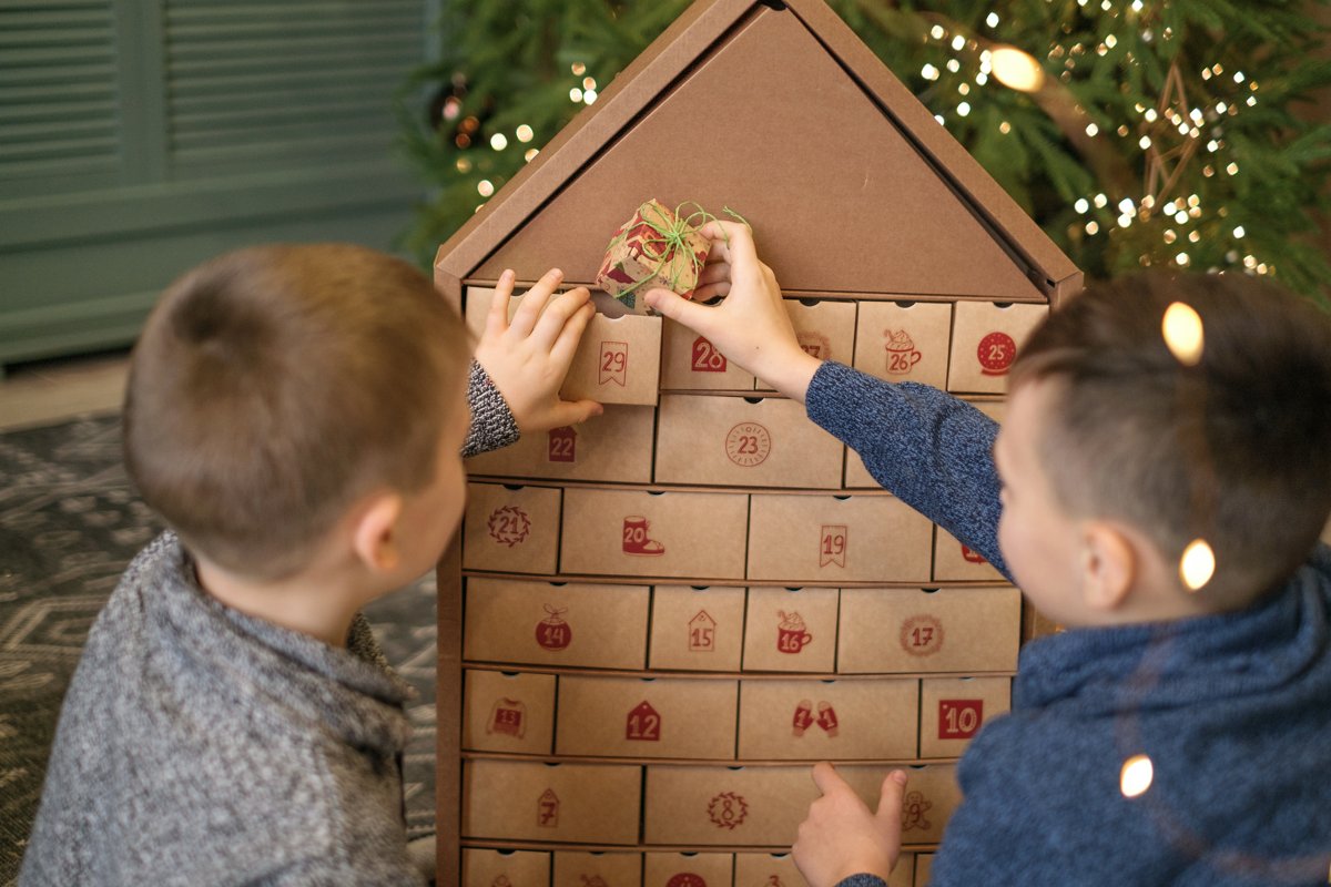 Two children opening the doors of a large advent calendar