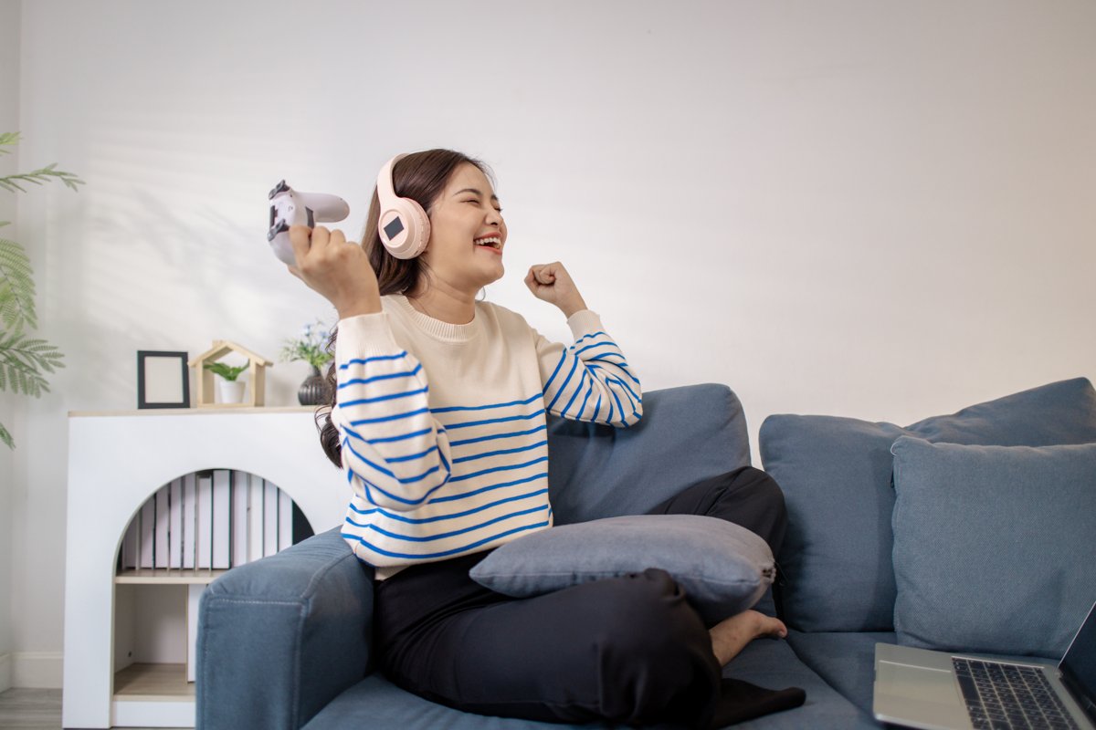 Femme souriante avec un casque audio sur le canape