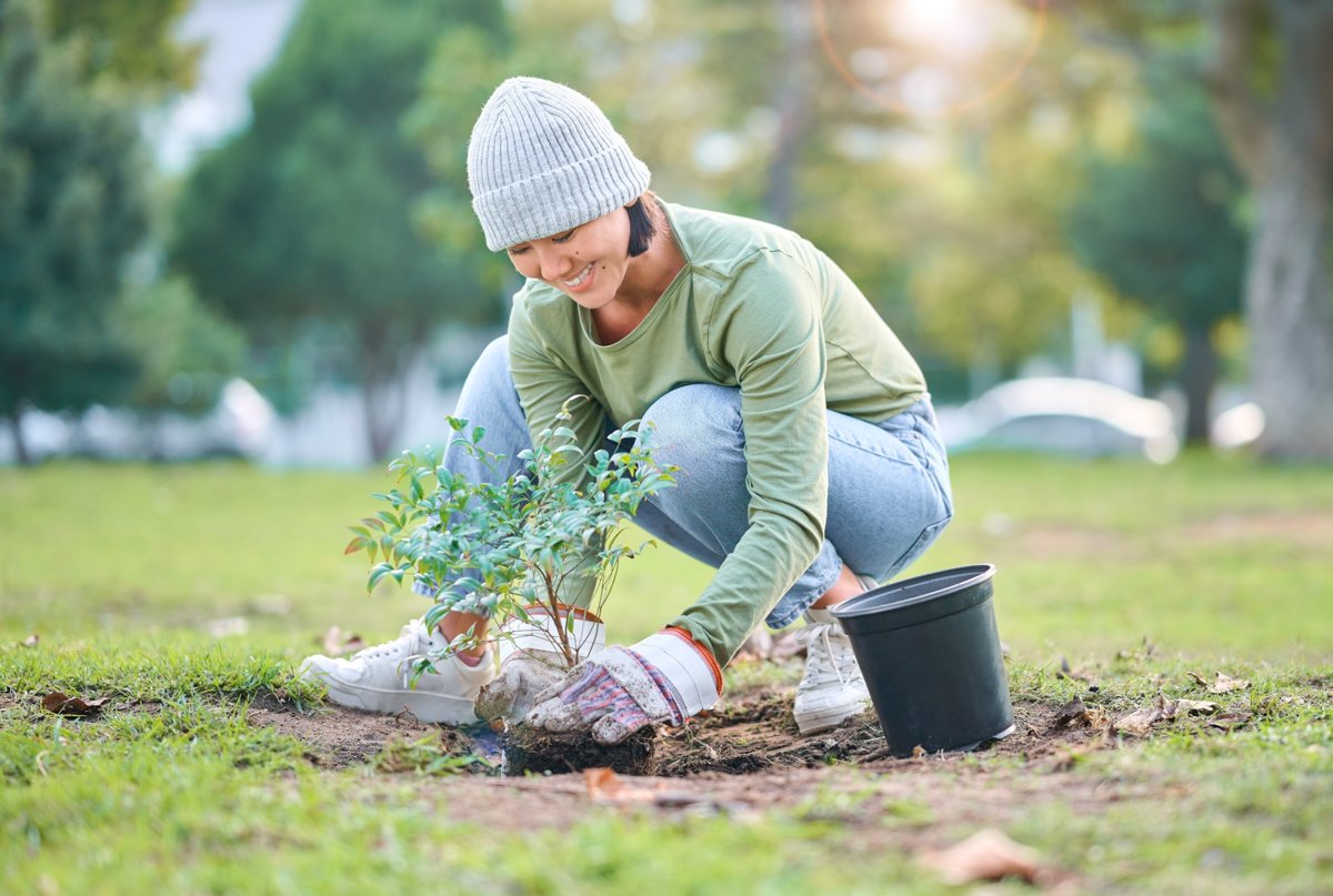 Woman smiling while doing fall yard work in the garden