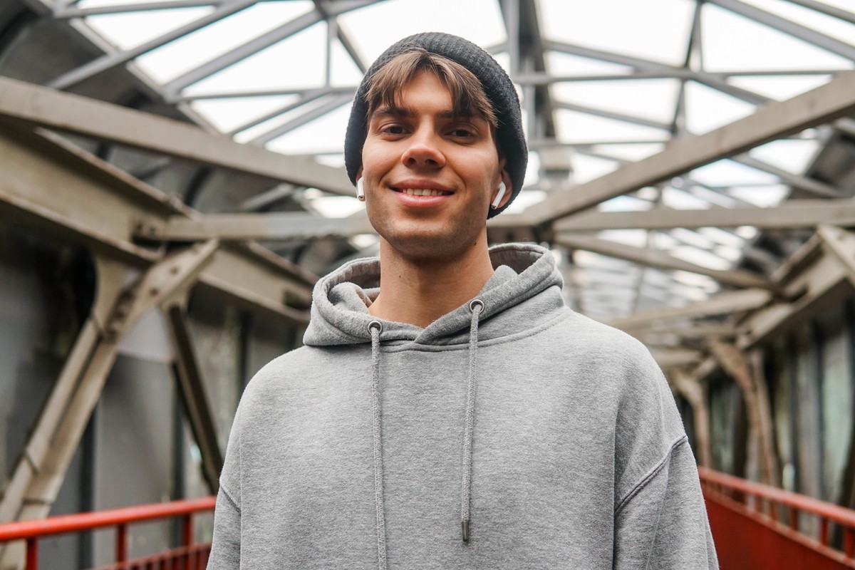 Smiling man in a grey hoodie and beanie