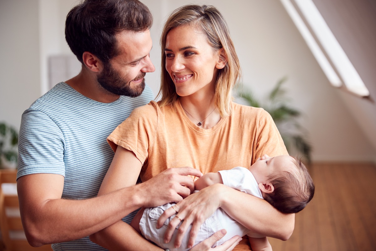 Parents souriants avec leur nouveau-né à la maison